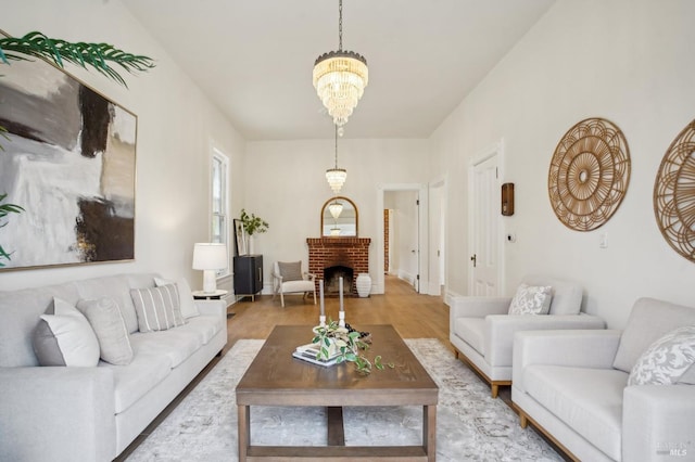 living room with a fireplace, a chandelier, and wood-type flooring