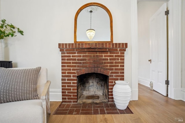 living room featuring hardwood / wood-style flooring and a brick fireplace