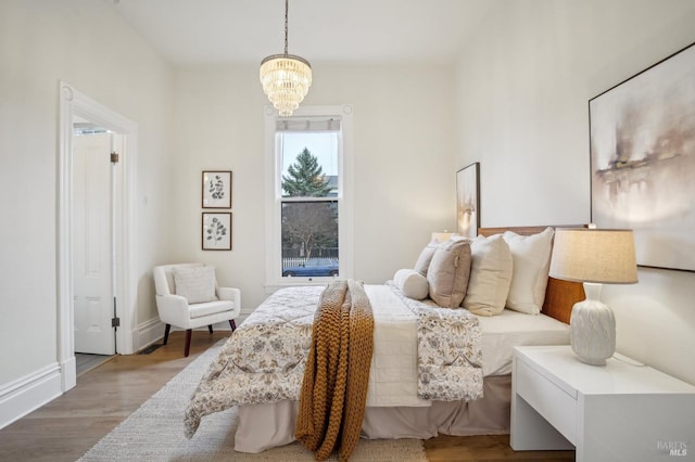 bedroom with hardwood / wood-style floors and a chandelier