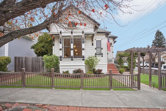 view of front facade featuring a pergola and a front yard