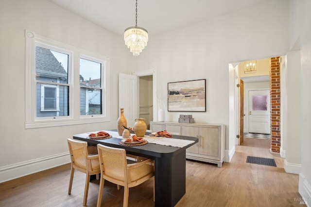 dining space with an inviting chandelier and light hardwood / wood-style floors