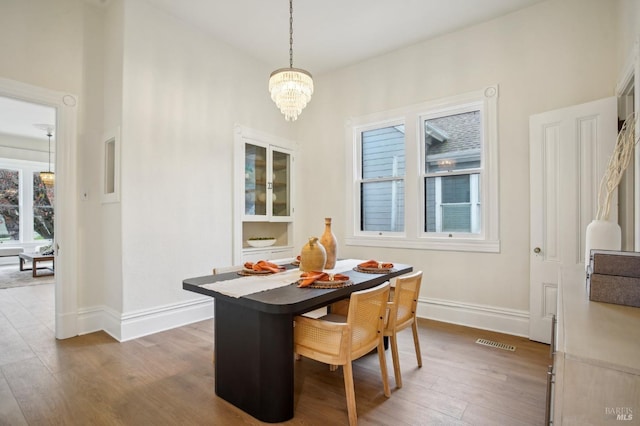 dining room featuring hardwood / wood-style flooring, plenty of natural light, and a notable chandelier