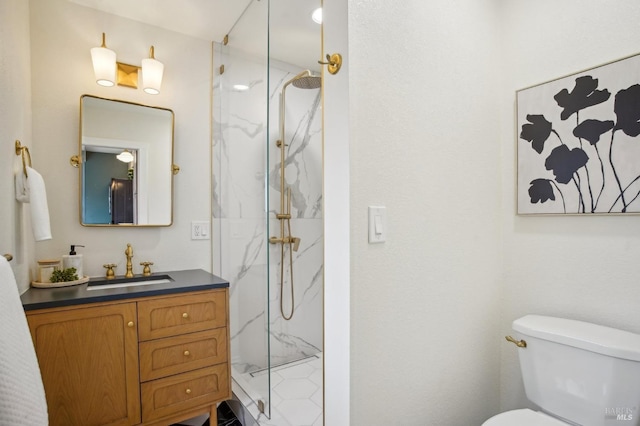 bathroom featuring a tile shower, vanity, and toilet