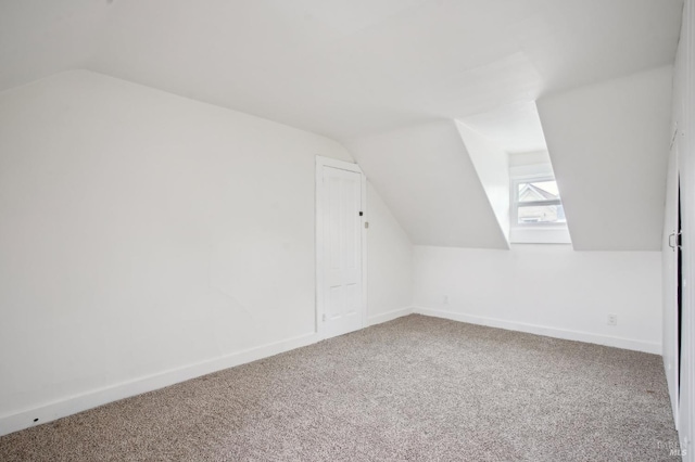 additional living space with carpet floors and vaulted ceiling