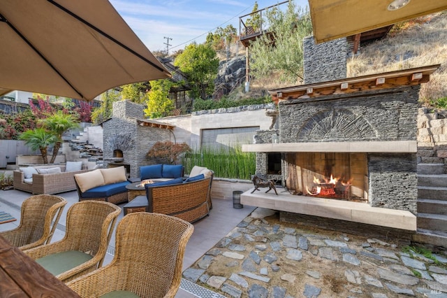 view of patio with an outdoor living space with a fireplace