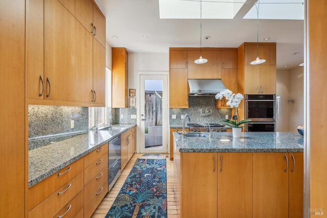 kitchen with a skylight, range hood, decorative light fixtures, decorative backsplash, and light wood-type flooring