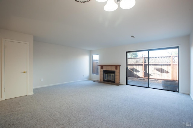 unfurnished living room with a tile fireplace and carpet floors