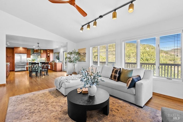 living room with ceiling fan, light hardwood / wood-style flooring, rail lighting, and lofted ceiling