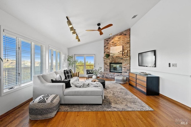 living room featuring plenty of natural light, wood-type flooring, and vaulted ceiling