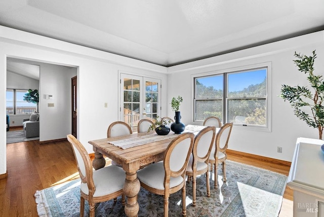 dining area with hardwood / wood-style floors, french doors, and lofted ceiling