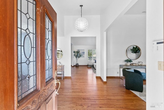 entryway with hardwood / wood-style floors and a chandelier