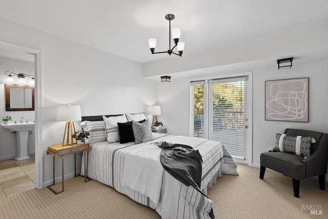 bedroom with a notable chandelier, access to outside, and connected bathroom