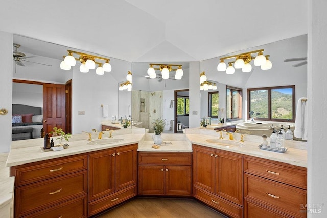 bathroom featuring hardwood / wood-style floors, vanity, lofted ceiling, ceiling fan, and walk in shower