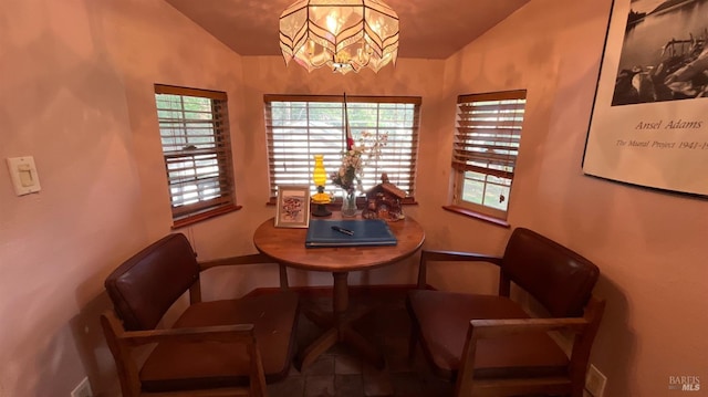 dining area with vaulted ceiling and an inviting chandelier