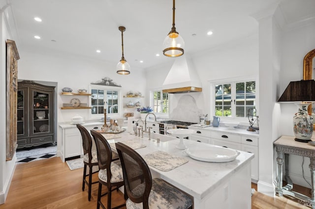 dining space featuring light wood-type flooring, crown molding, and sink