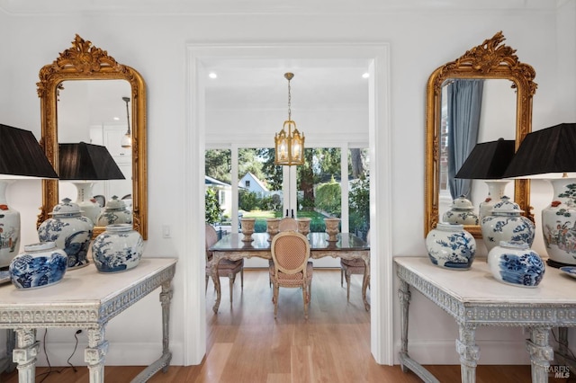 interior space with light hardwood / wood-style floors and a notable chandelier