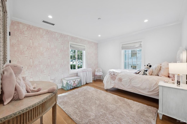 bedroom with hardwood / wood-style floors and crown molding