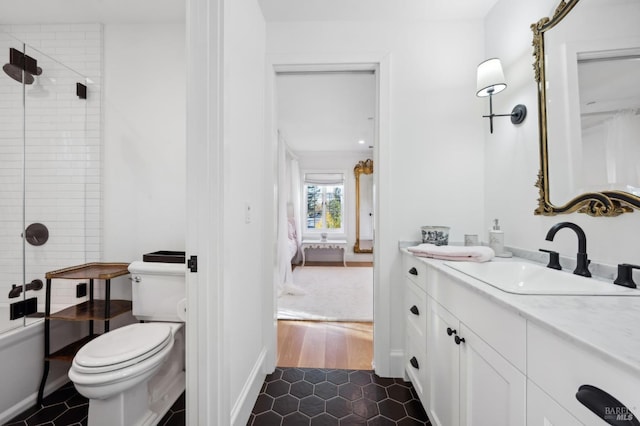 bathroom featuring vanity, wood-type flooring, an enclosed shower, and toilet