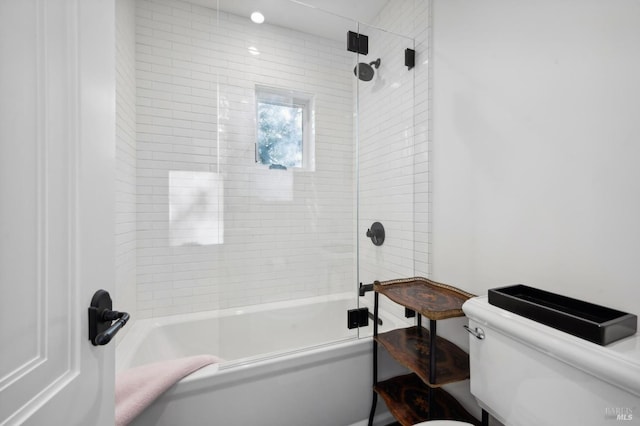 bathroom with tiled shower / bath combo and toilet