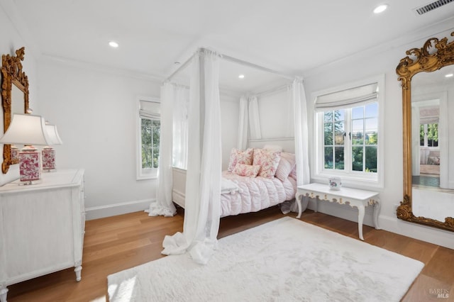 bedroom with light hardwood / wood-style floors and ornamental molding