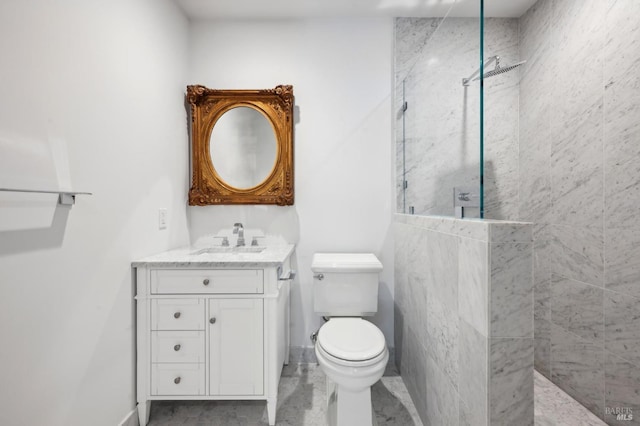 bathroom featuring tiled shower, vanity, and toilet