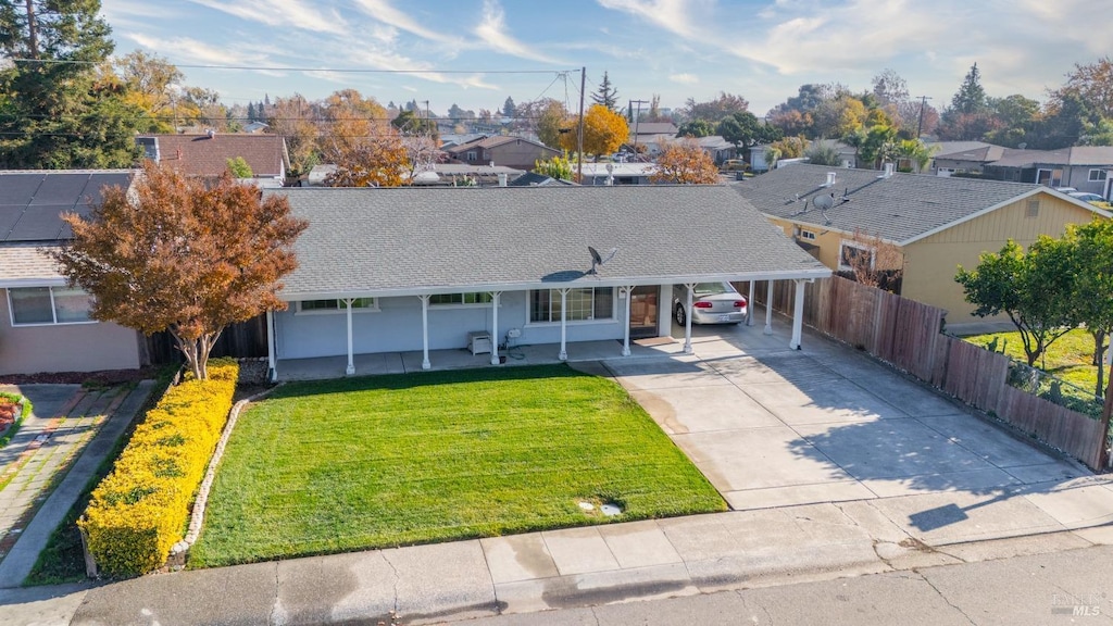 view of front of home with a carport and a front lawn