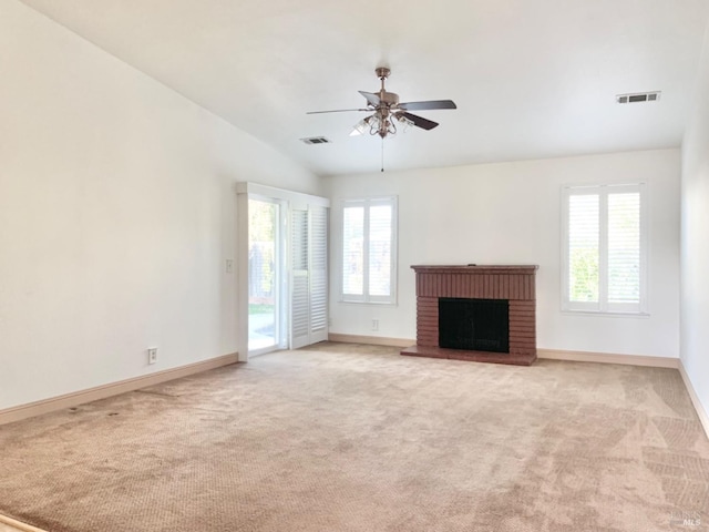 unfurnished living room featuring light carpet, a brick fireplace, lofted ceiling, and ceiling fan