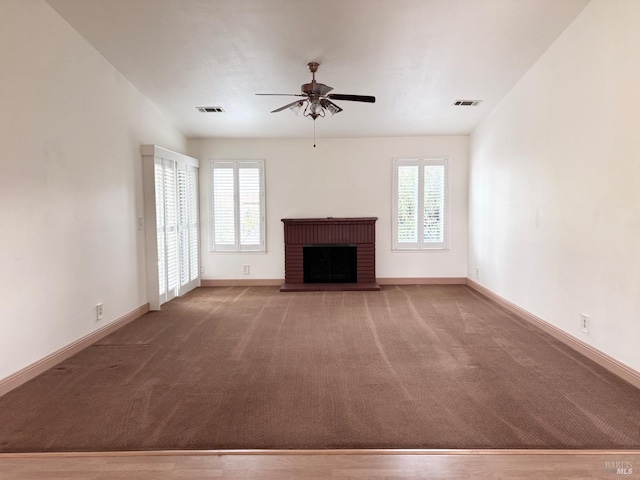 unfurnished living room with plenty of natural light, a fireplace, and visible vents