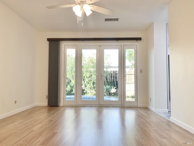 doorway to outside featuring ceiling fan, light wood-type flooring, visible vents, and baseboards