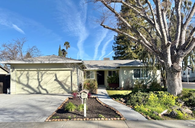 single story home with a garage, driveway, and a chimney