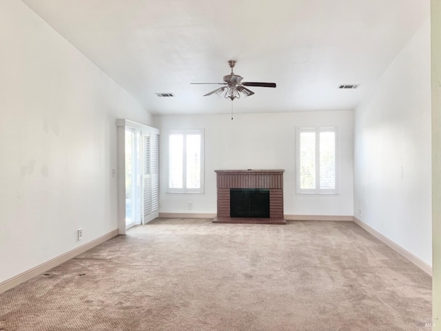 unfurnished living room with vaulted ceiling, ceiling fan, light carpet, and a brick fireplace