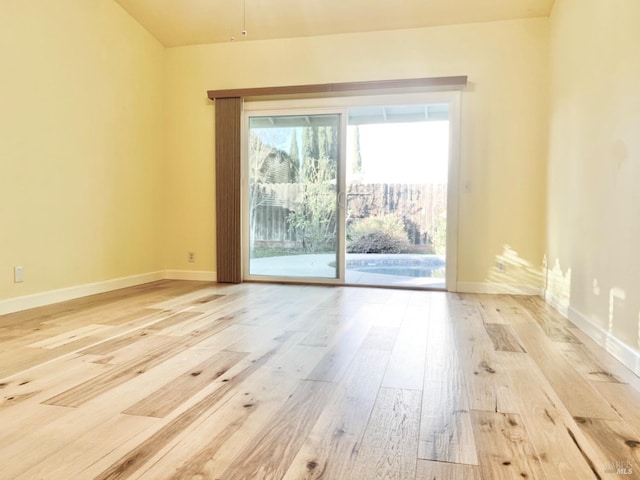 spare room featuring light wood-type flooring and baseboards