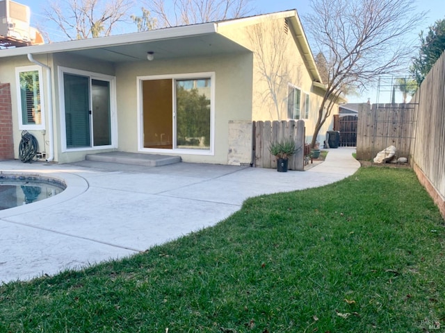 rear view of house with a fenced in pool, a lawn, a patio, and central air condition unit