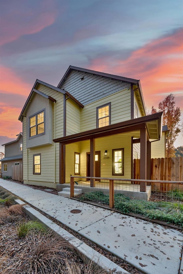 view of front of house with a porch and fence