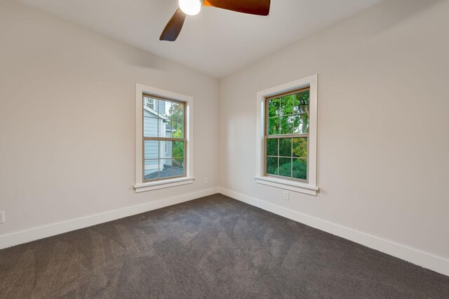 carpeted empty room with ceiling fan and plenty of natural light