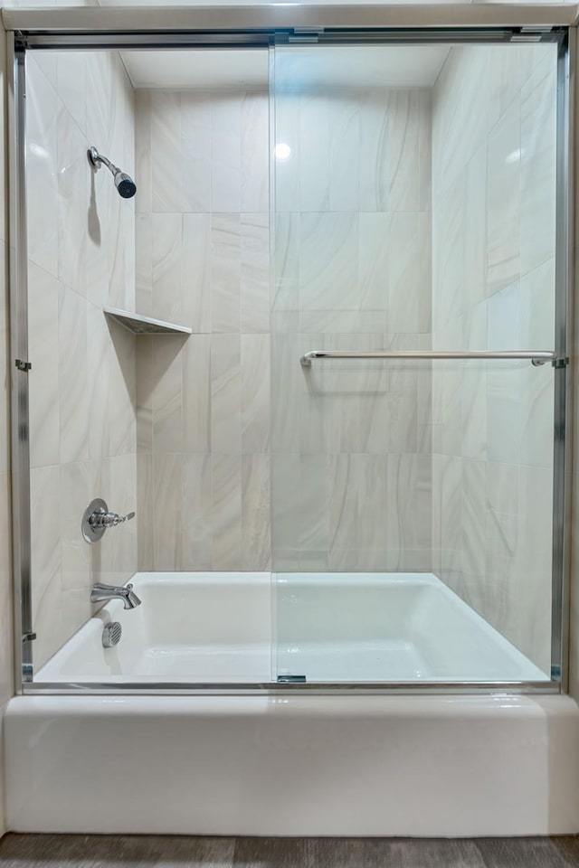 bathroom featuring combined bath / shower with glass door