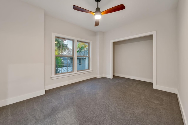 unfurnished bedroom featuring ceiling fan and dark carpet