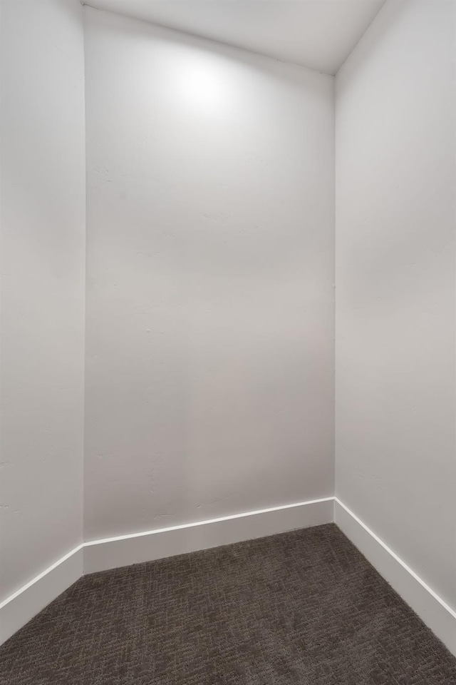 spare room with dark colored carpet