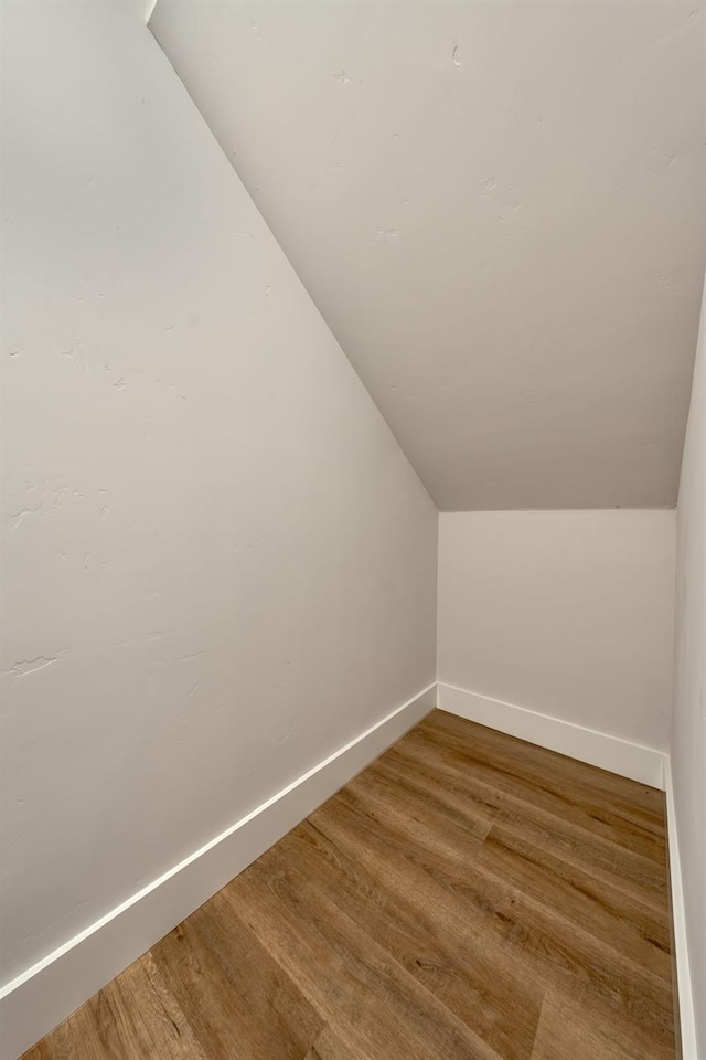 bonus room with lofted ceiling and wood-type flooring