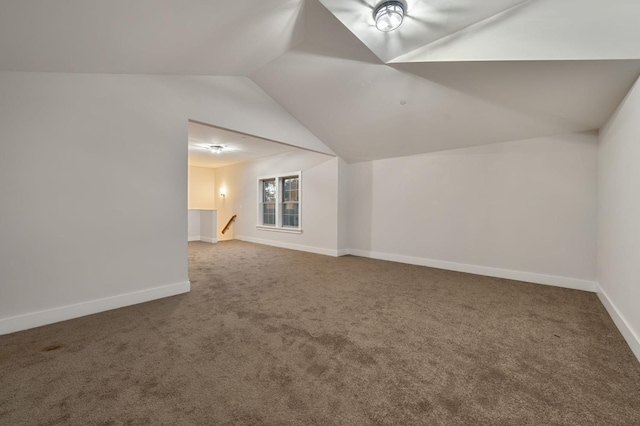 additional living space featuring vaulted ceiling and carpet floors