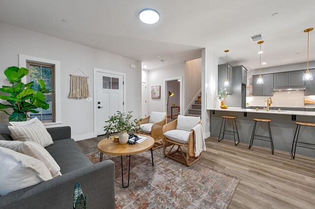 living room with light hardwood / wood-style floors and sink