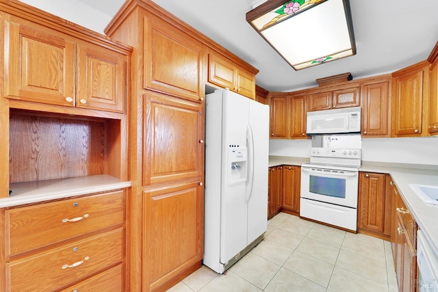 kitchen with light tile patterned floors, white appliances, and sink