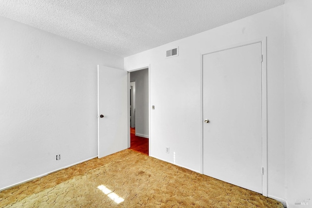 unfurnished bedroom with carpet floors and a textured ceiling