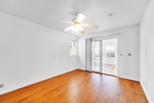 unfurnished room with ceiling fan, a textured ceiling, and hardwood / wood-style flooring