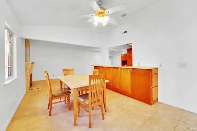 dining room featuring ceiling fan, lofted ceiling, and light tile patterned floors