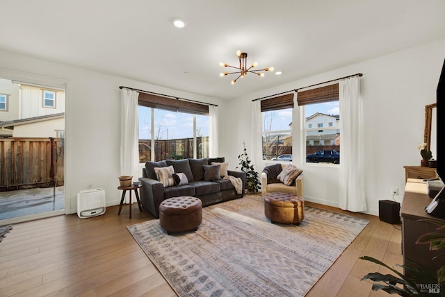 living room with hardwood / wood-style floors, a wealth of natural light, and a chandelier