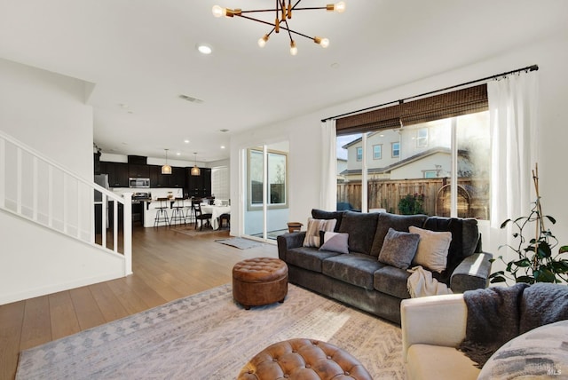 living room featuring wood-type flooring and a chandelier