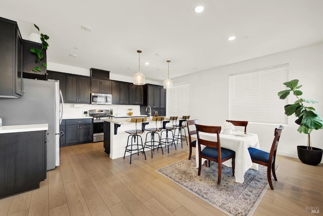 dining space featuring sink and light wood-type flooring