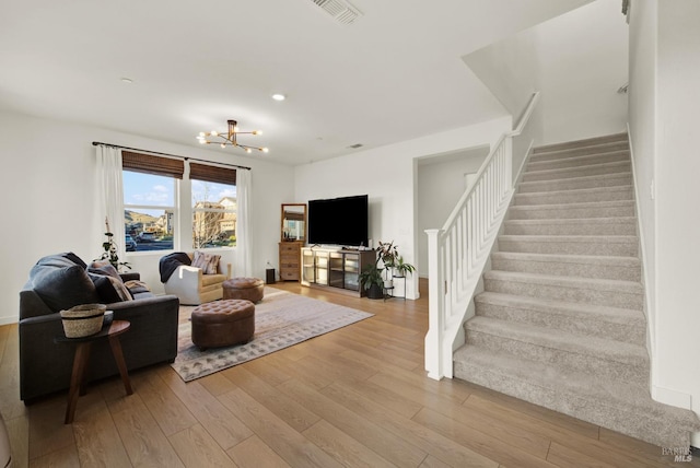 living room featuring light hardwood / wood-style flooring and a notable chandelier