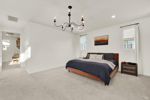 bedroom featuring light carpet and an inviting chandelier